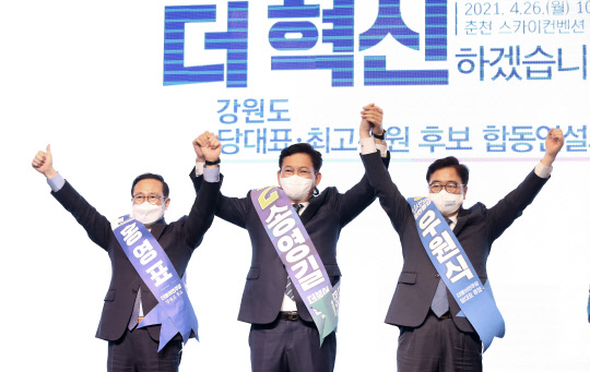 민주당 당권주자 3인방이 26일 강원 춘천시 스카이컨벤션에서 열린 민주당 당대표·최고위원 후보 합동연설회에서 함께 손을 들어 인사하고 있다. 왼쪽부터 홍영표 후보, 송영길 후보, 우원식 후보. 연합뉴스